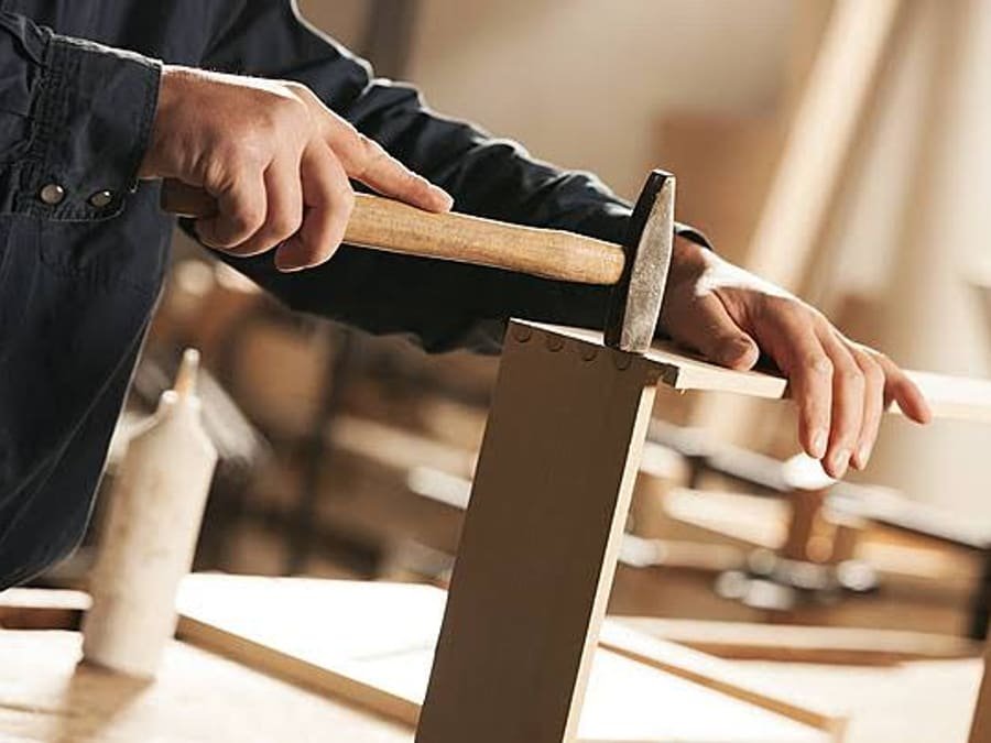Carpintero armando un mueble de madera en el taller